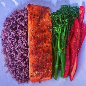 Cajun Baked Salmon, served with a side of multigrain rice, sweet broccolini and sweet red bell peppers