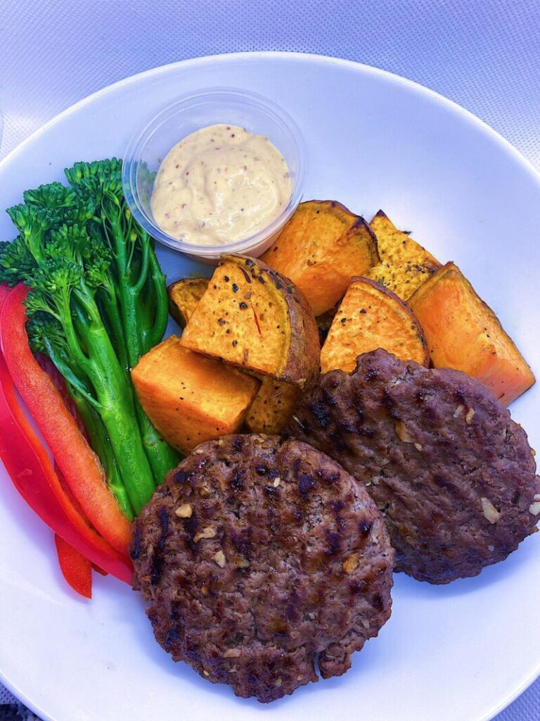 Hand Rolled Beef Burgers, with a side of sweet potatoes, mixed vegetables, and our delicious secret sauce